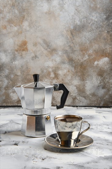 Geyser coffee maker and metal cup on abctract background