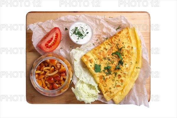 Top view of thin pancakes with honey mushrooms and tomato isolated on white background