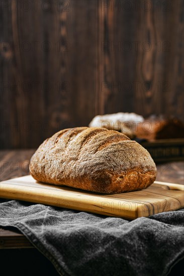 Loaf of artisan sourdough bread with porous texture on wooden table