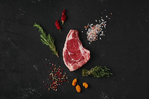 Top view of raw strip steak bone in on dark background