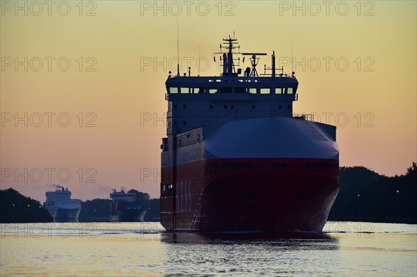 Cargo ships sailing at sunrise in the Kiel Canal