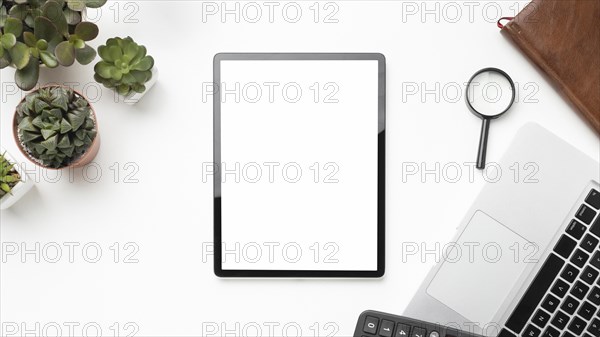 Flat lay desk elements arrangement with empty screen tablet