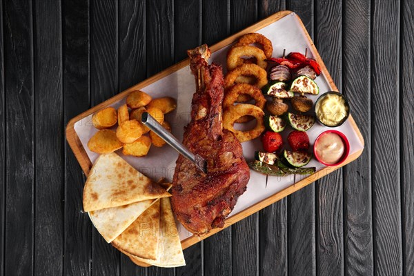 Fried turkey thigh with grilled vegetables and snack for beer