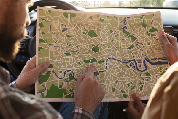 Man woman checking map car