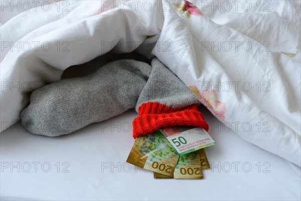 Banknotes in stocking under duvet