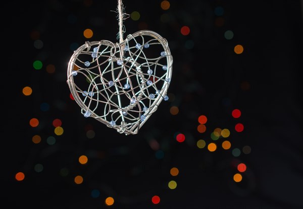 Heart shaped metal cage on a bokeh light background