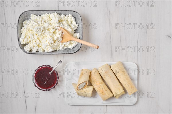 Overhead view of homemade pancakes stuffed with cottage cheese on marble serving plate