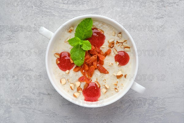 Top view of oatmeal with almonds and dried apricots in a bowl