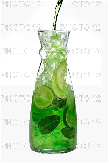 Filling up the jar with icy apple and lemon drink