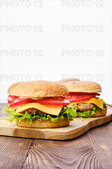 Four homemade burgers on wooden serving board