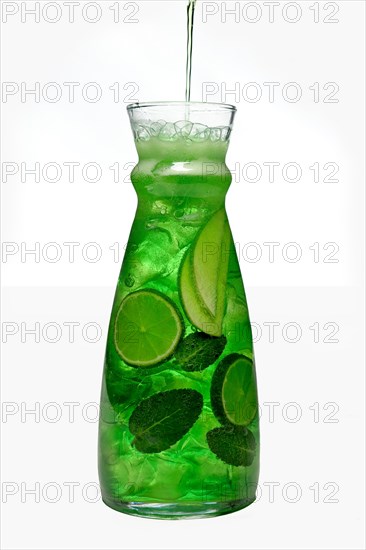 Filling up the jar with icy apple and lemon drink