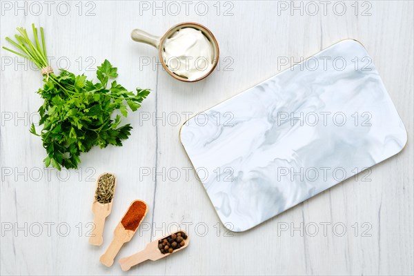 Top view of white table with marble serving plate and spice