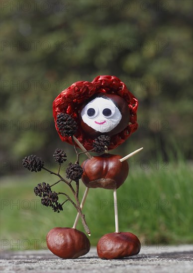 Chestnut figure with hat wearing black alder cones