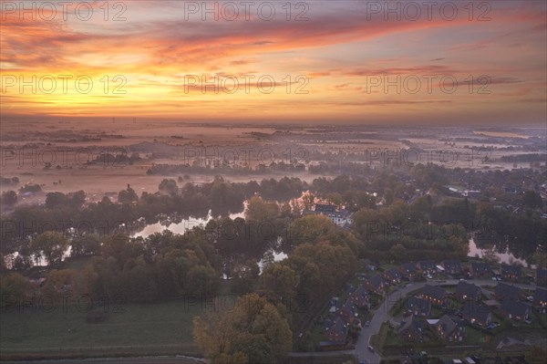 Aerial view of the landscape around Sandbraak Lake near Fuenfhausen in Hamburg's Kirchwerder district in autumnal morning atmosphere with light ground fog. In the foreground the residential area Fritz-Bringmann-Ring
