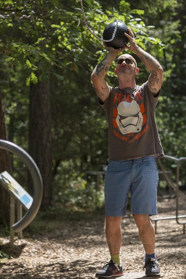 Man playing basketball on a trim trail