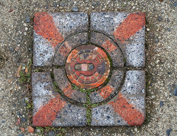 Red marked stone cover over a water hydrant connection