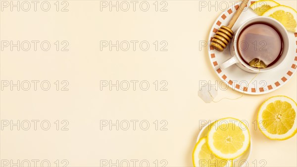 Black tea with slice fresh lemon beige background