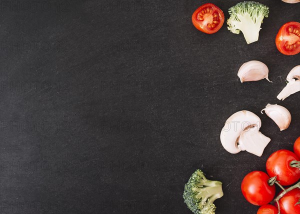 Broccoli cherry tomatoes mushroom garlic cloves white textured background