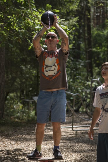 Man playing basketball on a trim trail