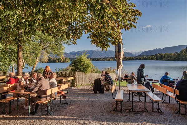 Beer garden at Staffelsee with Ester Mountains in the evening sun