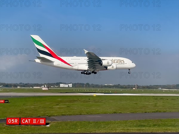 Large aircraft for intercontinental flights jet passenger aircraft jet Emirates Airbus A380-800 A6-EEH on approach just in front of touch down landing touchdown on runway of Duesseldorf International Airport