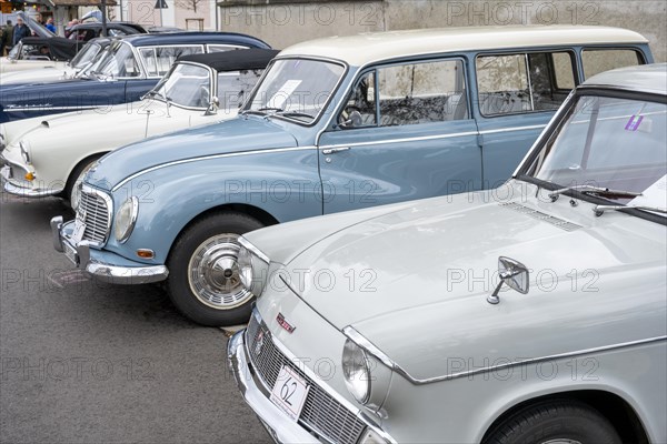Vintage cars built around 1960 lined up in a car park