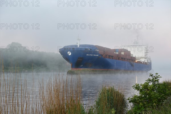 Container ship Delphis Finland sailing through the Kiel Canal in fog