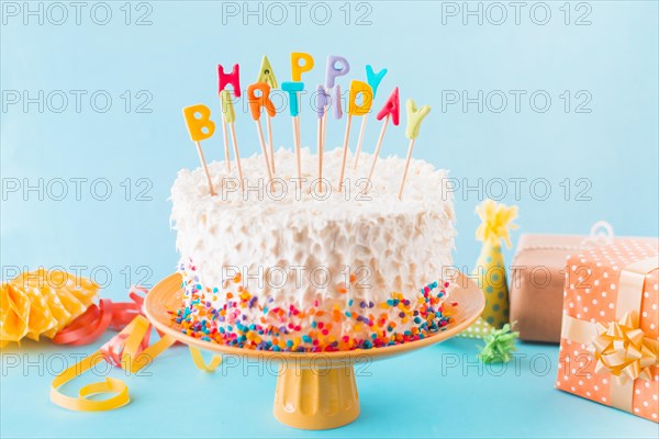 Birthday cake with gift accessories blue background
