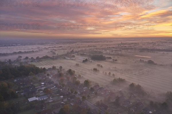 Aerial view of the landscape near Fuenfhausen in Hamburg's Kirchwerder district in autumnal morning atmosphere with light ground fog. In the background the nature reserve Kirchwerder Wiesen. Fuenfhausen