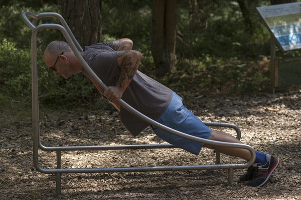 Man doing push-ups on a trim trail