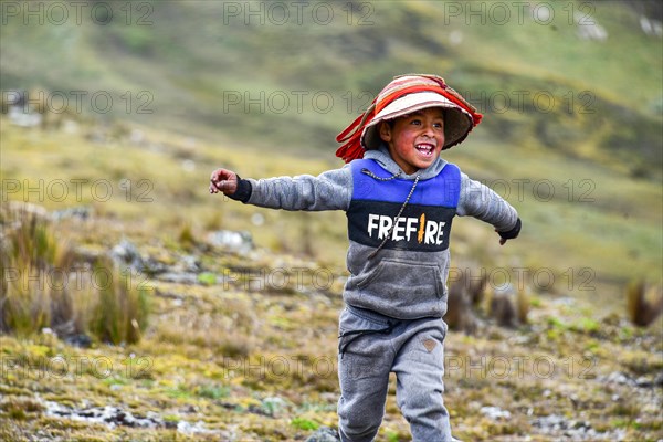 Running boy with traditional hat in the Andes