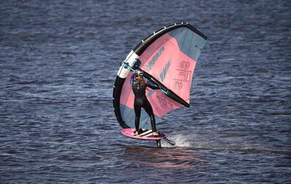 Young woman windsurfing Wingfoil at the North Sea