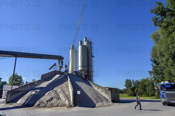 Steel silos and shovel crane with gravel piles and conveyor belt
