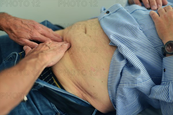 This internist in the centre of a larger city works mainly as a family doctor. The photo shows: Examination of the abdomen