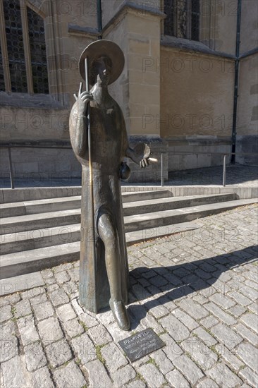 Pilgrim statue in front of the Protestant St. Jakob's Church with inset floor plate to the Way of St. James to Santiago de Compostella