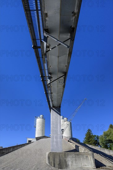 Steel silos and shovel crane with gravel piles and conveyor belt