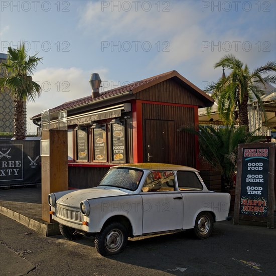 Trabi at a snack bar with palm trees at the egg cooling house