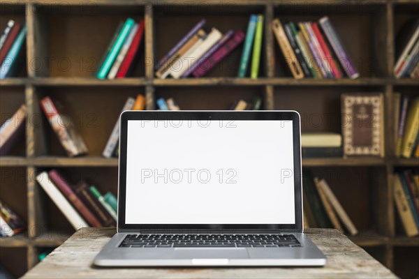 Blank screen open laptop wooden desk library