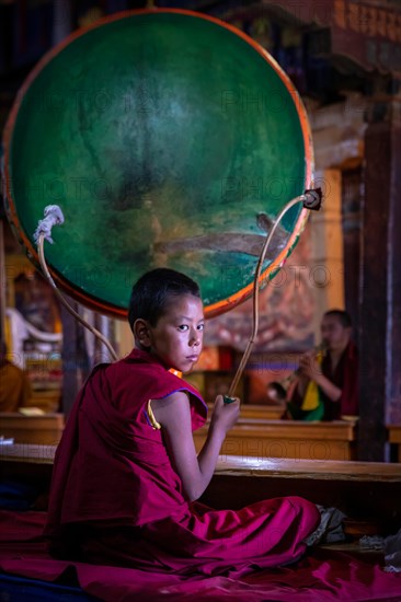 A young monk with a drum at Spituk Monastery