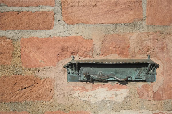 Letterbox with lizard figure and house number 2