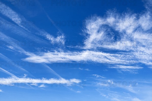Blue sky with Cirrus feather clouds on the left Cirrocumulus cluster clouds on the right