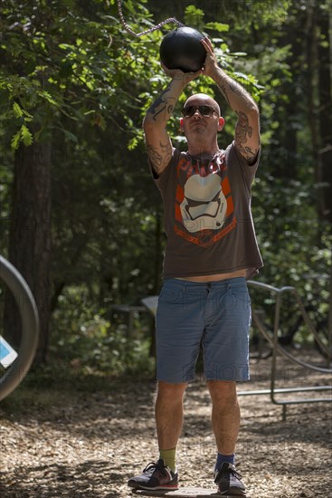 Man playing basketball on a trim trail