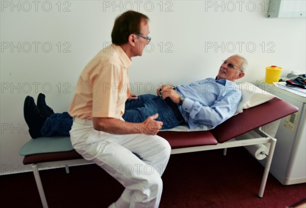 This internist in the centre of a larger city works mainly as a family doctor. The photo shows: Examination of the abdomen