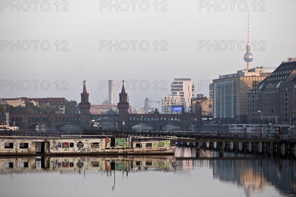 Shipwreck of the MS Dr. Ingrid Wengler in the Spree in the early morning with Oberbaum Bridge and Fernsehturm