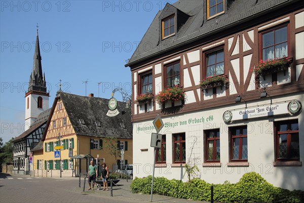 Half-timbered house Gasthaus zum Engel and steeple of St. Mark's Church with people