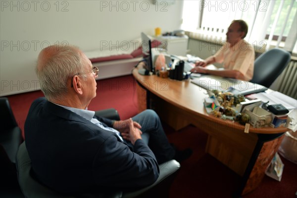 This internist in the centre of a larger city works mainly as a family doctor. The photo shows: Consulting a patient