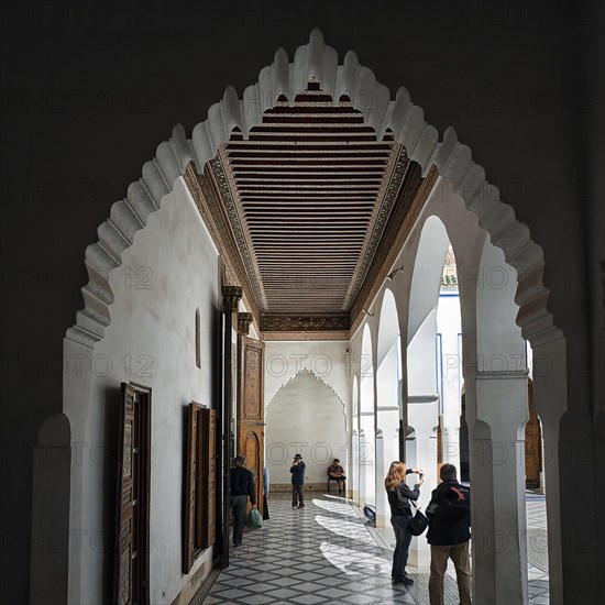 View through arched door to arcade with ornate wooden ceiling