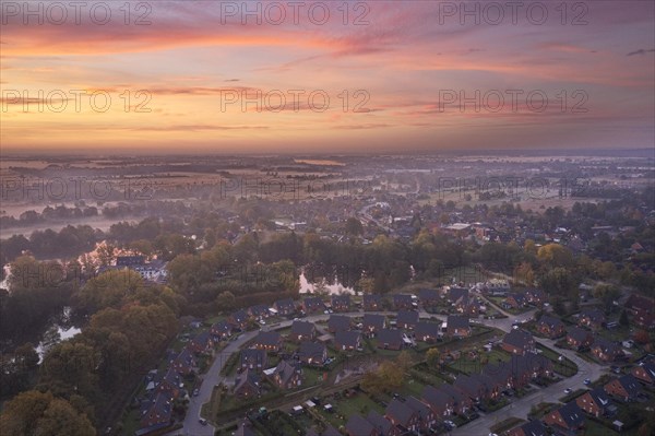 Aerial view of the landscape around Sandbraak Lake near Fuenfhausen in Hamburg's Kirchwerder district in autumnal morning atmosphere with light ground fog. In the foreground the residential area Fritz-Bringmann-Ring