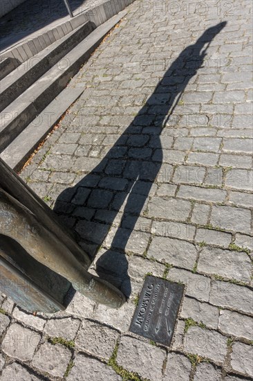 Foot of the pilgrim statue in front of the Protestant St. Jakob's Church with inset floor plate to the Way of St. James to Santiago de Compostella