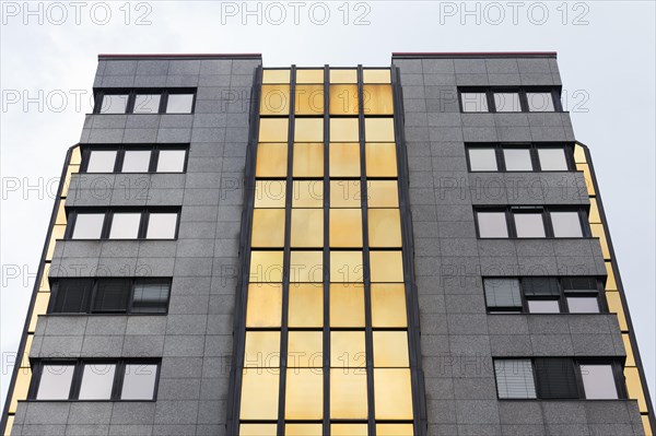 Older office tower with window panes in gold bronze